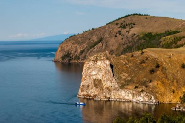 Büyük kayaların arka planda küçük bir gemi ... Baykal Gölü'nde tekne yelkenleri.