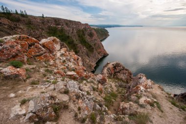 Baykal Gölü'ndeki Olhun Adası'ndaki Üç Kardeş Kayası. Ön planda kırmızı yosun ile güzel taşlar.