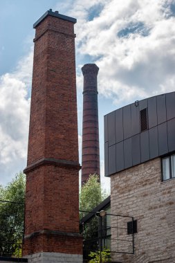 Krematoryumun yüksek tuğlaları gökyüzüne karşı bulutlarla kaplı. Kare tüp ve yuvarlak. Borulardan duman çıkmıyor..
