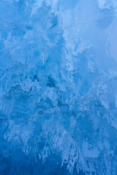 Melting ice of Lake Baikal with an internal structure. Amazing ice pattern while melting. Air bubbles and strings. Selective focus on the bottom. Vertical.