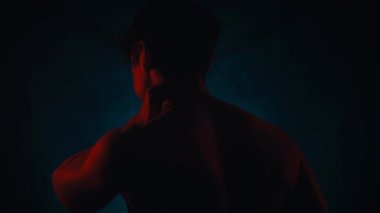 Mavi arka plan üzerinde izole siluet stüdyoda bir kosasian adam boyun ağrısı portre