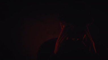 Kırmızı arka plan üzerinde izole siluet stüdyoda bir kosasian adam baş ağrısı ağrı portre