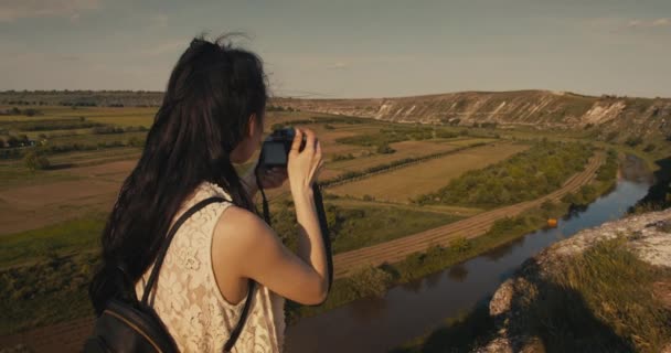 Mladá ženská turistka, která si v létě fotografovat malebný kaňon. — Stock video