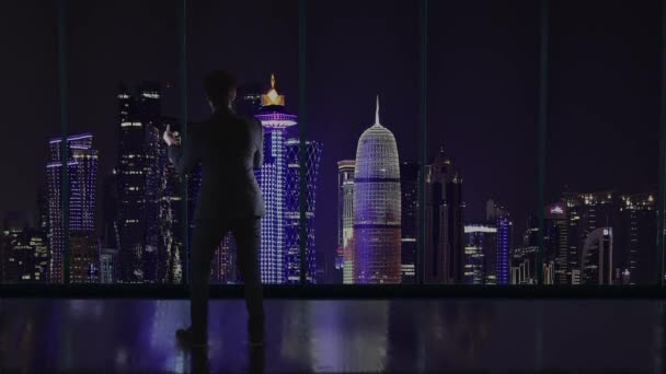 ドーハ クタールの景色を眺めながら大きな窓の前に立ち 中指を見せるオフィスの傲慢なビジネスマンのシルエット — ストック動画