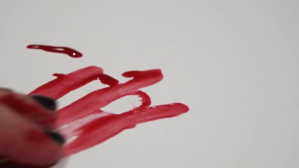 Main féminine prend une alliance couverte de sang .