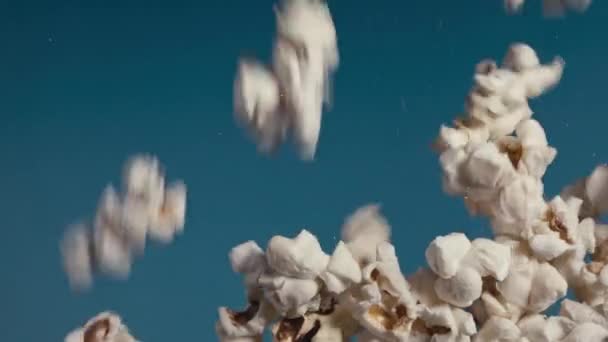 Białe Puszyste Kawałki Popcorn Spada Wolnym Tempie Stos Siebie Niebieskim — Wideo stockowe