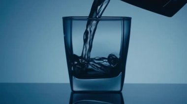 Yavaş çekim. Bir bardağa viski dökmek ve bardağı almak.