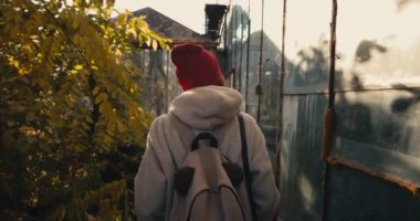 Sırt çantalı çekici bayan turist terk edilmiş Sovyet binalarını keşfediyor..