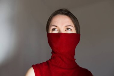 Tıbbi maske yerine boğazlı yakalı bir kadın.