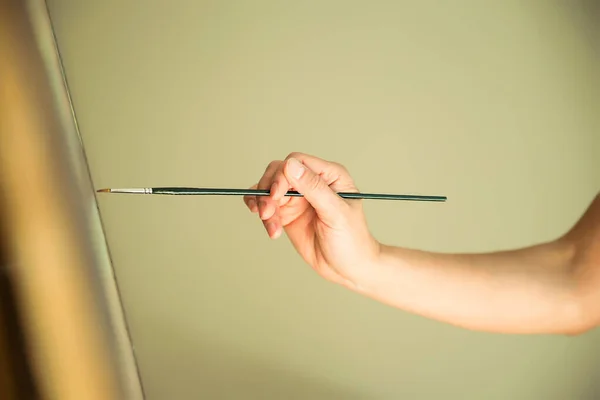 Vrouwelijke Hand Met Een Artistieke Borstel Schilderij Neutrale Beige Achtergrond — Stockfoto