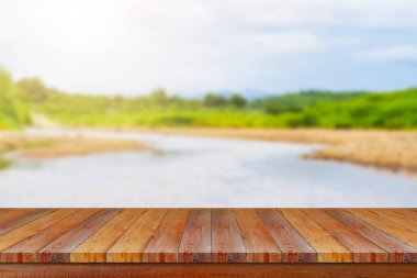 Nehir zemininde yumuşak güneş ışığı olan ahşap masa