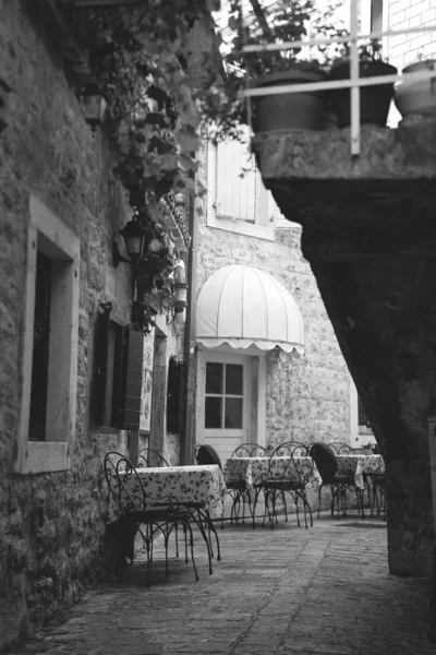 cafe on narrow street in the old town italia. Medieval architecture of a small town. Beautiful view of scenic narrow street with historic traditional houses in an old idyllic town in Europe.