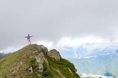 Genç bayan yürüyüşçü yürüyüş gezisinde güzel dağlarda oturur. Doğada dinlenen aktif bir insan. Kamp yapan sırt çantalı gezgin etkinleştirildi