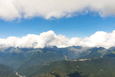 Muhteşem panoramik manzara muazzam dağlardaki kozalaklı orman ve güzel mavi gökyüzü arkaplanı. Vahşi bakire Rus doğasının güzelliği. Huzur..
