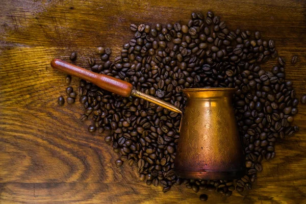 Turkish coffee concept. Copper coffee pot (Cezve), vintage coffee grinder, cup, coffee beans on a dark wooden background. Top view. horizontal.
