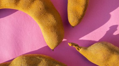 Pembe arka planda kahverengi demirhindi kapsülü