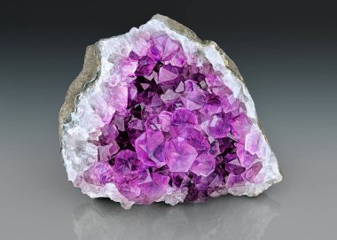 Menekşe Crystal taş makro mineral. Mor kaba ametist kuvars kristalleri Jeod gri degrade arka plan, Uruguay