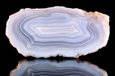 Bölümü kesim çizgili akik kristal şaşırtıcı yansıması ile siyah arka plan üzerine izole. Doğal ışık şeffaf akik kristal yüzey, gri Soyut yapı dilim mineral taş makro portre