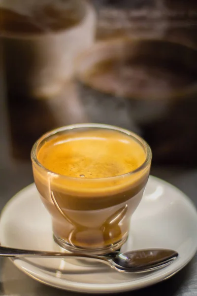 bir fincan sıcak kahve koyu arka plan üzerine bir çay kaşığı ile bir daire üzerinde.