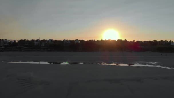 鸟瞰在罗塔 卡迪兹的海滩上日出 你可以看到3个人坐在沙滩上 另一个人在散步 在福多你看见房子和树木 太阳在底部 — 图库视频影像
