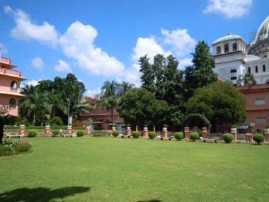 Hindistan'da Mayapur de renkli çiçek ve diğer güzel yapılar ile yeşil ağaçlar ve bitkilerin güzel bir bahçe.