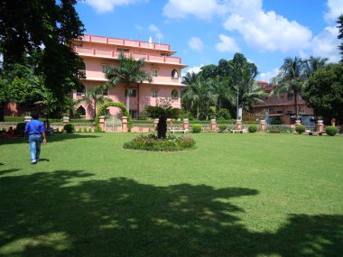 Hindistan'da Mayapur de renkli çiçek ve diğer güzel yapılar ile yeşil ağaçlar ve bitkilerin güzel bir bahçe.