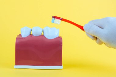 Diş fırçası ile sarı arka plan üzerinde yanlış ağız