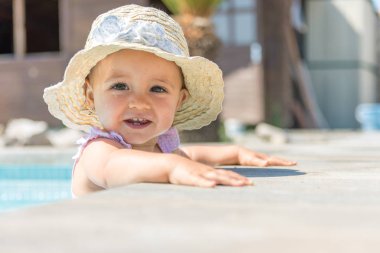 Yüzme havuzunda izole şapkalı kız bebek.