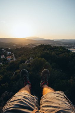 Güzel bir gün batımına bakan yüksekliklerde asılı iki bacak
