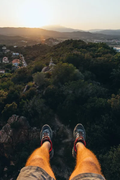Two legs hanging on the heights overlooking a beautiful sunset