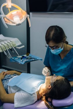 bir diş hekimi kız ile bir diş kliniğinde beyaz bir kız beyaz diş parantez yerleştirme süreci