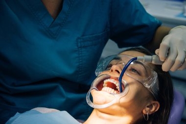 bir diş hekimi kız ile bir diş kliniğinde beyaz bir kız beyaz diş parantez yerleştirme süreci