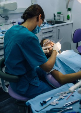 bir diş hekimi kız ile bir diş kliniğinde beyaz bir kız beyaz diş parantez yerleştirme süreci