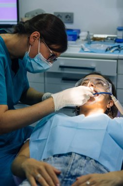 bir diş hekimi kız ile bir diş kliniğinde beyaz bir kız beyaz diş parantez yerleştirme süreci