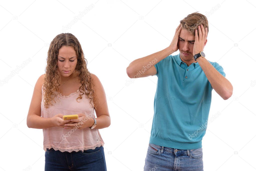 Young Caucasian couple or brothers receiving bad news on their mobile phone looking worried or shocked in white background isolated, boy dressed in blue shirt and pink girl
