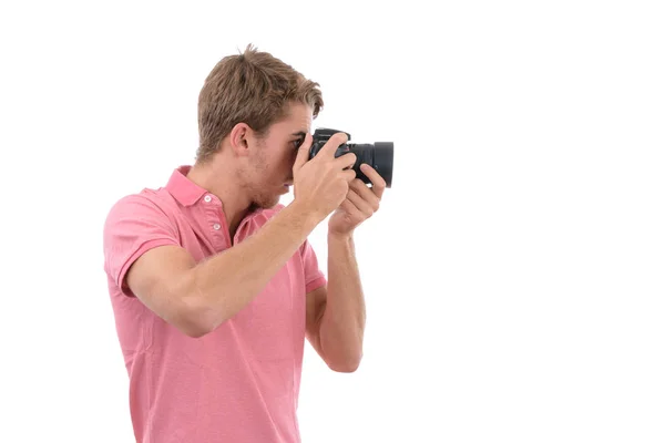 Young Caucasian man taking pictures with photo camera on isolated white background — Stock Photo, Image