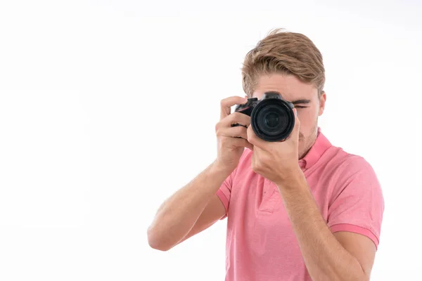 Jonge blanke man neemt foto 's met fotocamera op geïsoleerde witte achtergrond — Stockfoto