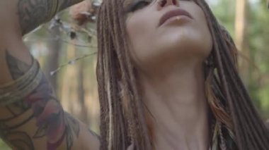 Güzel bir kostüm içinde dans vücut afro-örgü ve dövmeler ile Çekici dryad veya orman peri. Orman yaratığının eski ritüeli. Ormanda dansçı performansı