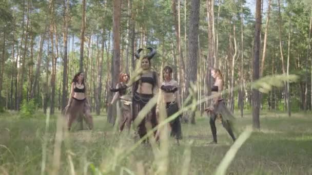 Νέες γυναίκες σε θεατρικά κοστούμια των δασών κορίτσια χορεύουν στο δάσος δείχνοντας υπέρβαση ή κάνοντας τελετουργίες — Αρχείο Βίντεο