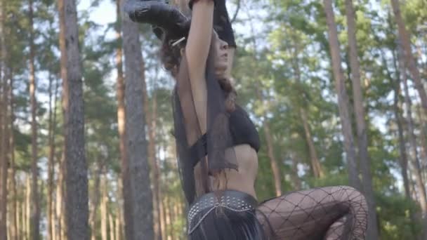 Mujeres jóvenes con disfraces de habitantes del bosque o demonios bailando en el bosque mostrando perfomance o haciendo rituales . — Vídeo de stock