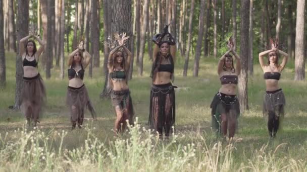 Orman da bulunan ların ya da şeytanların tiyatro kostümlü genç kadınları ormanda arap dansı yapan perfomance gösteren veya ritüel yapan — Stok video