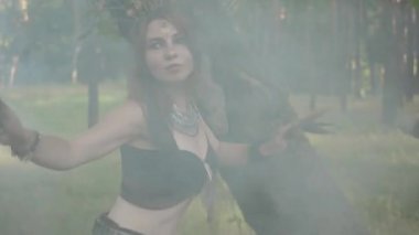 Çekici dryads veya orman perileri ağaç gövdesi arkasından çıkan ve duman bulutu içinde güzel kostümleri dans. Orman yaratıklarının eski ritüeli. Ormanda dansçıların performansı
