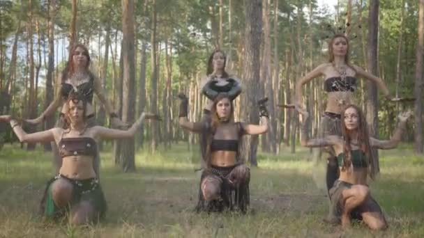 Молодые женщины в театральных костюмах лесников или дьяволов, демонстрирующих перфоманс в зачарованном лесу . — стоковое видео