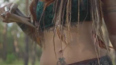 Tiyatro kostüm ve orman perisi makyaj sevimli genç çekici kadın performans gösteren ormanda dans veya ağaçların altında antik ritüel yapma. Kamera yukarı hareket ediyor