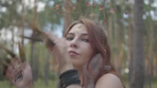 Portrait de jeune femme en costume théâtral et composition de nymth de forêt dansant dans la forêt montrant la parfumerie ou faisant le rituel 