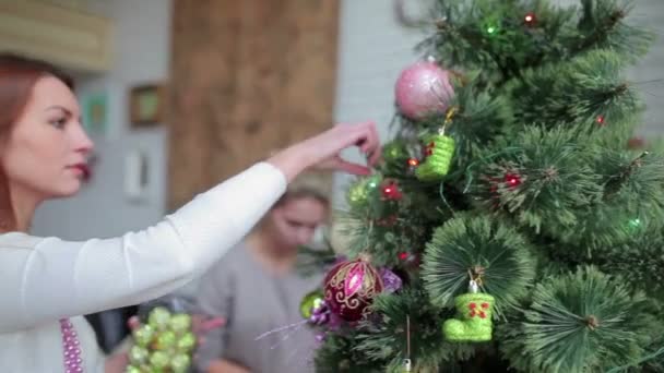 Kaukasische Frauen Schmücken Weihnachtsbaum Hause Mit Glänzenden Kugeln Und Spielzeug — Stockvideo