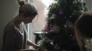 parlak topları ve oyuncaklar ile evde Noel ağacı dekorasyon kadınlar, çok renkli çelenk ışıkları ile ağaç yanıp sönen, video