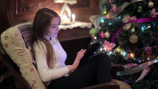 Vídeo Mulher Branca Sentada Poltrona Perto Árvore Natal Usando Tablet — Vídeo de Stock