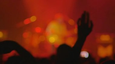 sahnede oynayan müzisyenler, bir yandan diğer yana havada el sallayan kalabalık, video