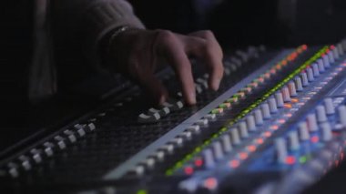 video, kontrol panelinde ses ayarlayan adam ellerin kısmi görünümü  